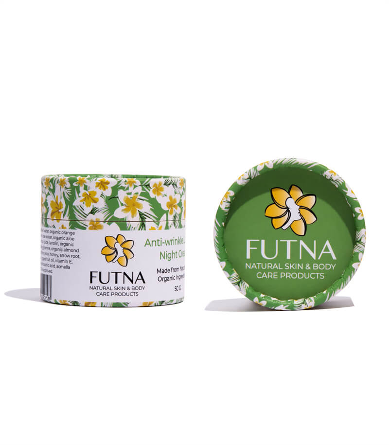 A cylindrical paper container with vibrant yellow flowers and green background, topped with a green lid displaying a flower logo. It suggests organic skin and body care, showcased against a white setting.