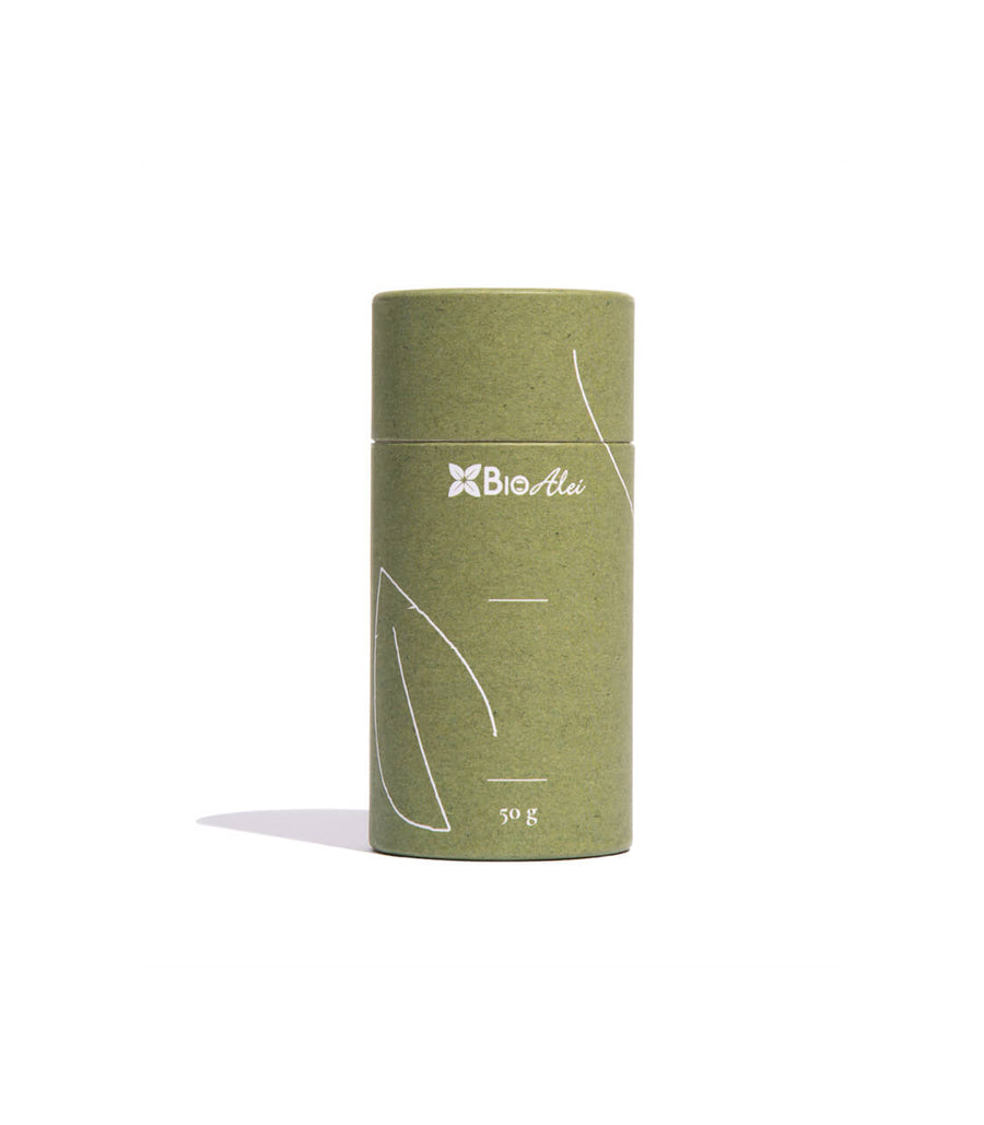 A cylindrical paper tube with a minimalist design. The tube is green and a brand logo was printed on the top. And its body has a leaf pattern made of lines. Below the logo, there's text that indicate the weight of the product contained within, which is "50g".