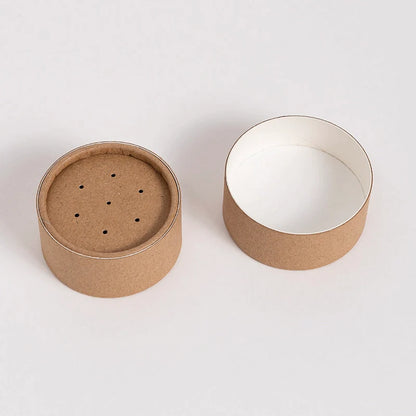Two parts of a disassembled kraft paper shaker tube are presented side by side; one with a perforated lid and the other showing a clean white interior.