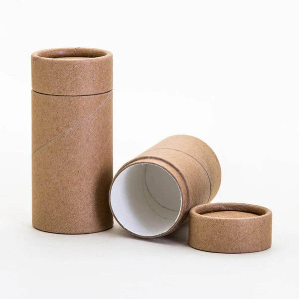 Two cylindrical brown containers, one open showing white interior, arranged against a light background, eco-friendly push-up tube packaging.