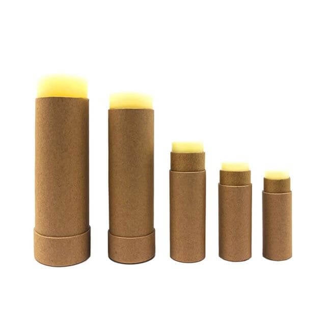 Five brown cardboard cylindrical containers with lip balms in decreasing size order on a white background.