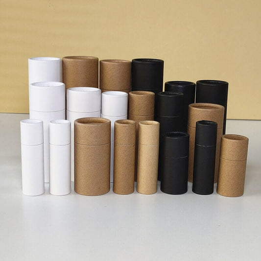 A variety of white, brown, and black paper tubes in multiple sizes, stacked and arranged against a yellow and beige background.