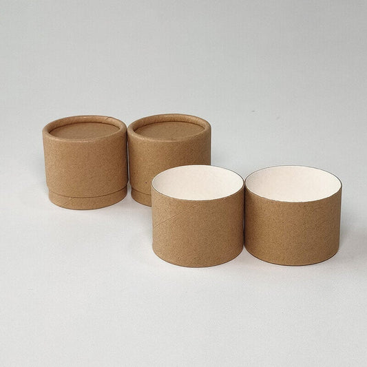 Three cylindrical brown kraft paper tubes with open tops showing a white interior, displayed on a light grey background. The front tube’s separated lid and base reveal its two-piece design.